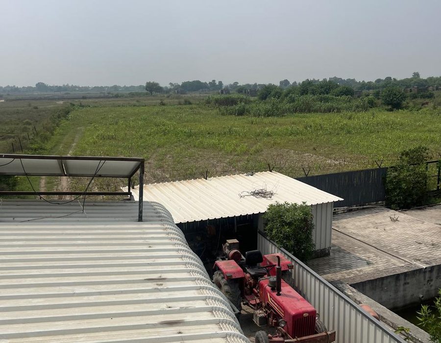 The farm tractor parked under its shed